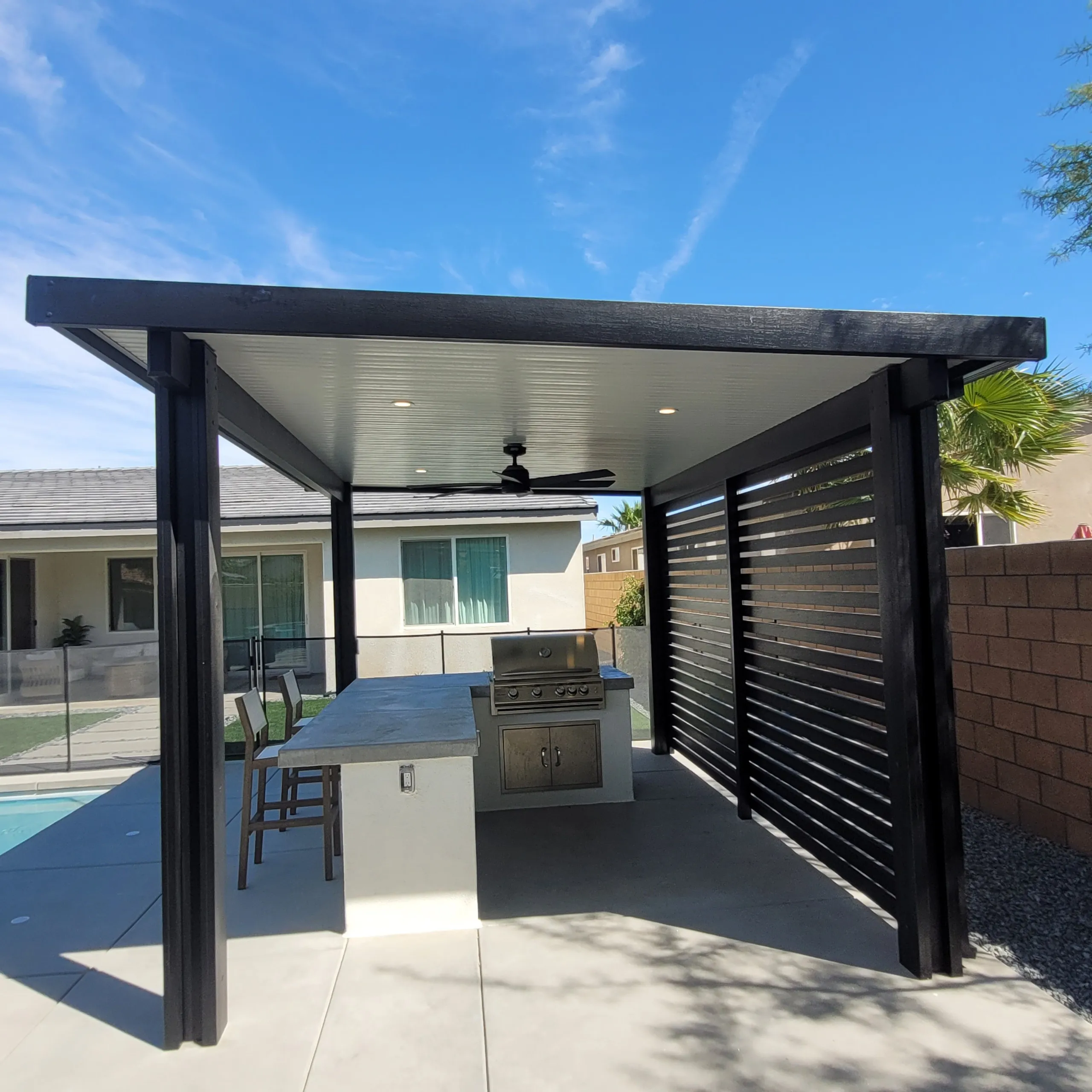 Freestanding solid patio cover in Ebony and White with privacy wall