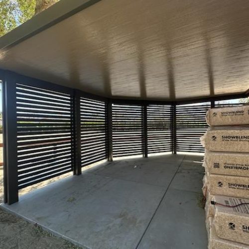 An aluminum patio cover with privacy walls is great storage on a ranch